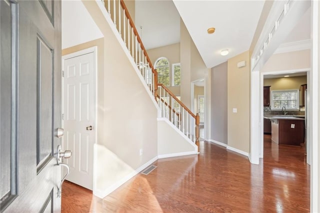 entrance foyer with crown molding, sink, and hardwood / wood-style flooring