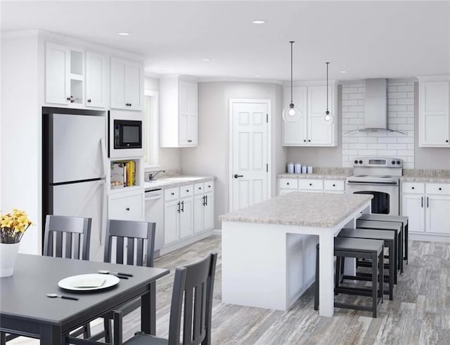 kitchen with wall chimney range hood, refrigerator, white cabinetry, a center island, and range with electric stovetop