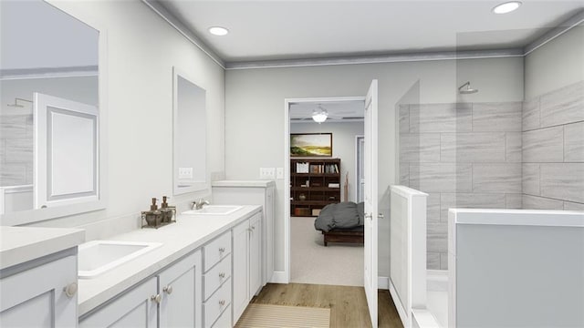 bathroom featuring vanity, hardwood / wood-style floors, and a tile shower