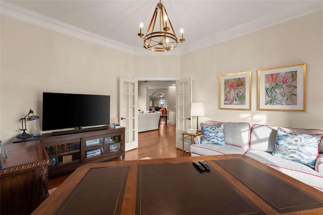 living room featuring french doors, a notable chandelier, crown molding, and hardwood / wood-style flooring