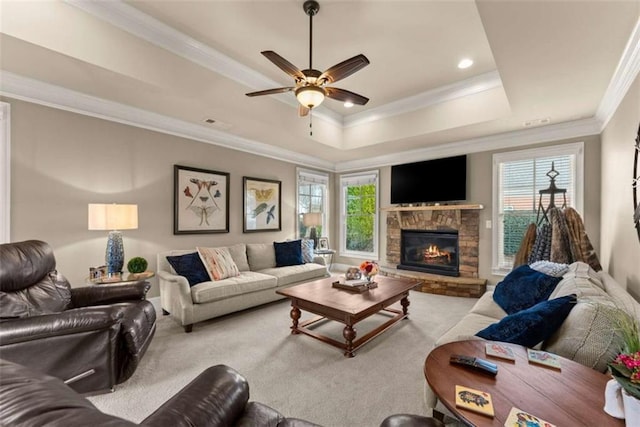 living room with ornamental molding, a healthy amount of sunlight, light carpet, and a tray ceiling