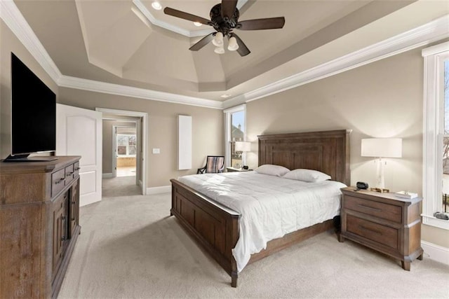 bedroom featuring crown molding, light colored carpet, a tray ceiling, and ceiling fan