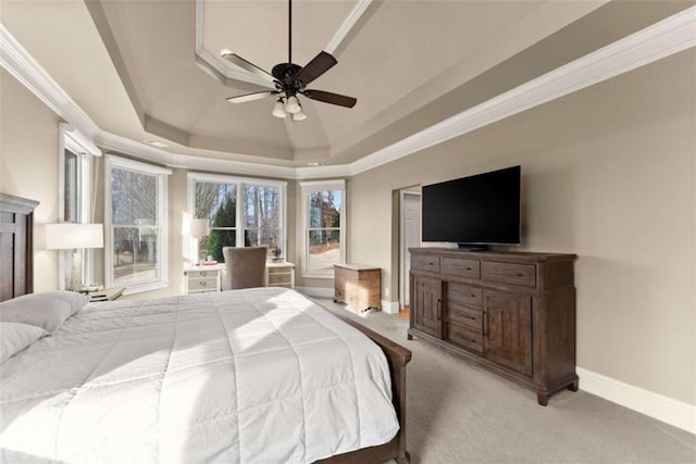 bedroom featuring crown molding, light colored carpet, a tray ceiling, and ceiling fan