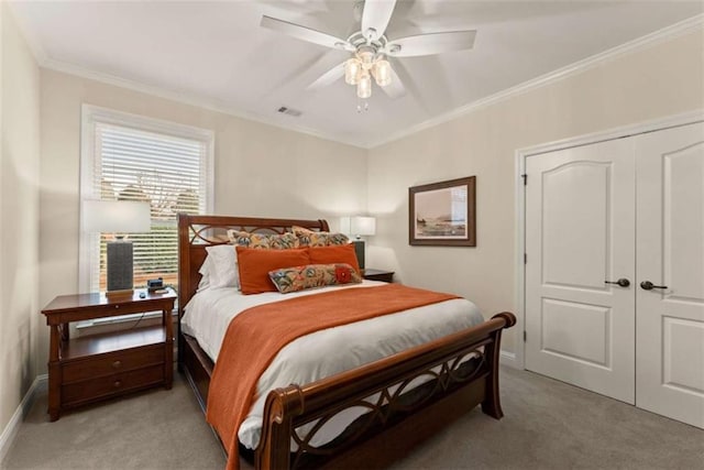 bedroom featuring light carpet, ornamental molding, a closet, and ceiling fan