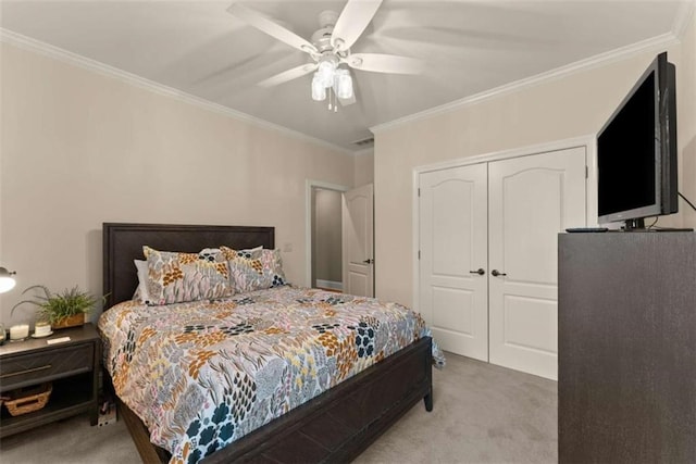 bedroom featuring ornamental molding, light colored carpet, a closet, and ceiling fan