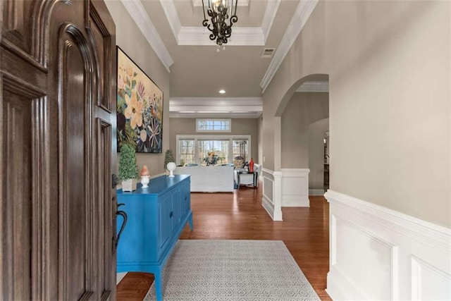 hallway featuring crown molding, an inviting chandelier, dark hardwood / wood-style flooring, and a tray ceiling