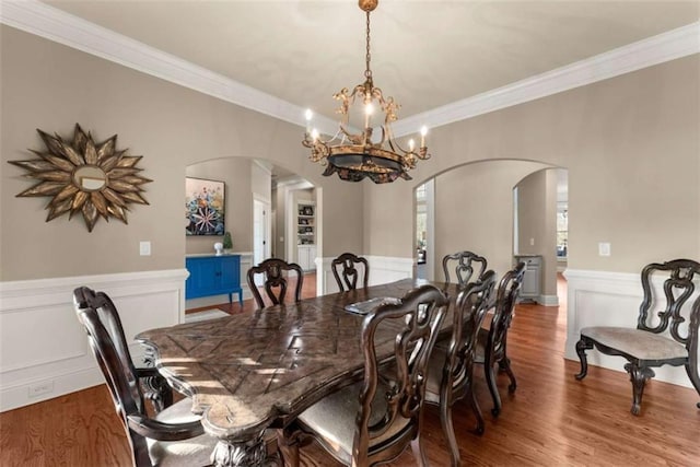 dining area with crown molding, a chandelier, and hardwood / wood-style floors