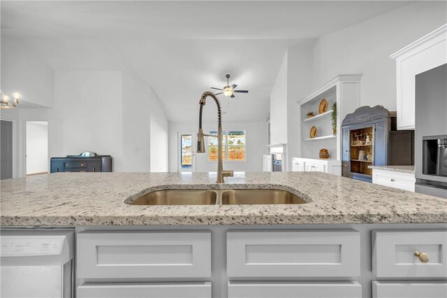 kitchen featuring light stone countertops, sink, white cabinets, and dishwashing machine