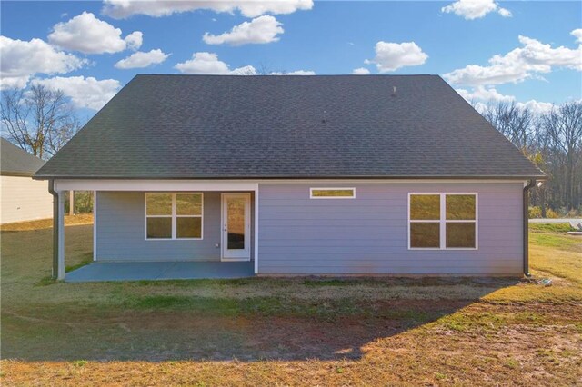 back of property with a patio area and a lawn