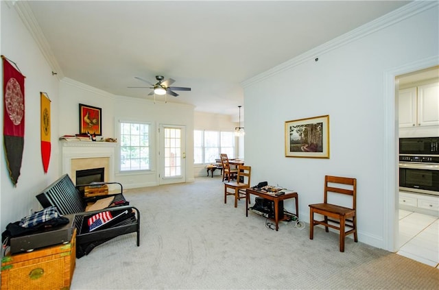 sitting room with crown molding, light colored carpet, and ceiling fan