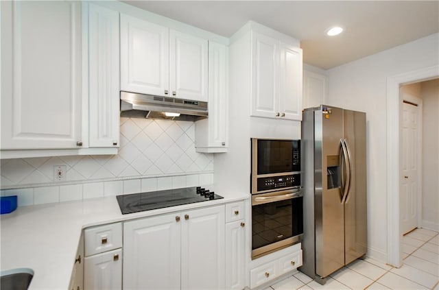 kitchen with appliances with stainless steel finishes, light tile patterned flooring, and white cabinets