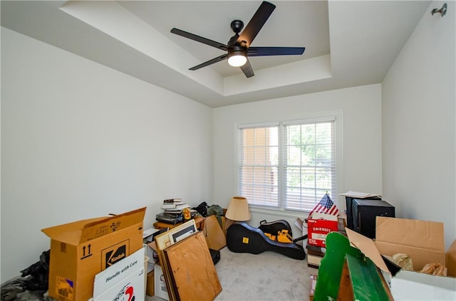 playroom featuring ceiling fan, a raised ceiling, and carpet flooring