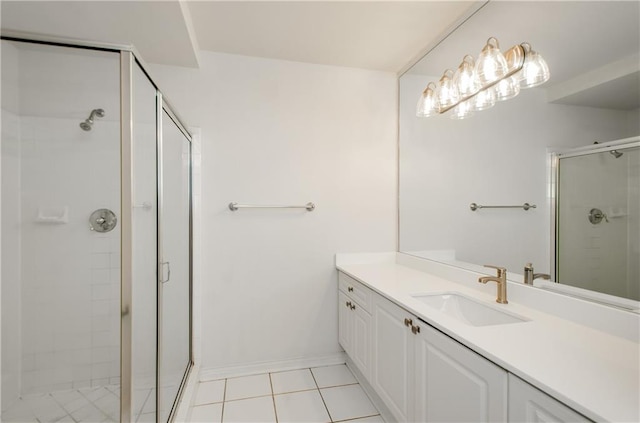 bathroom featuring a shower with shower door, vanity, and tile patterned floors