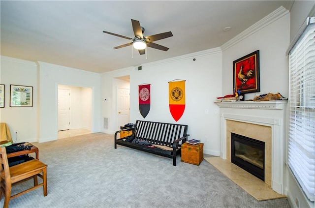 living area featuring a premium fireplace, light colored carpet, crown molding, and ceiling fan