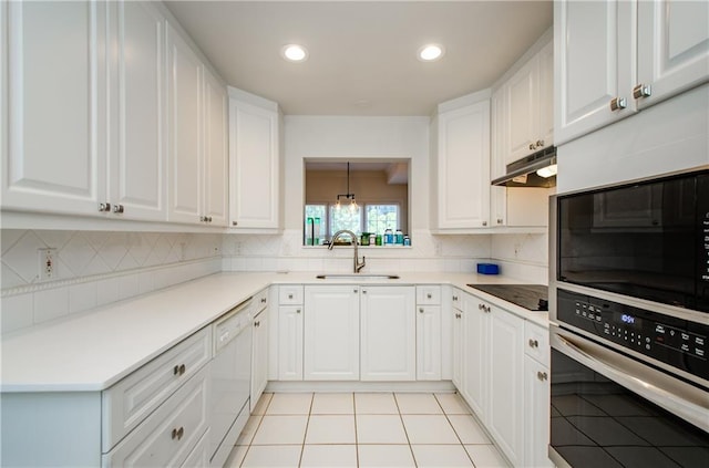 kitchen featuring light tile patterned flooring, hanging light fixtures, white cabinets, sink, and backsplash