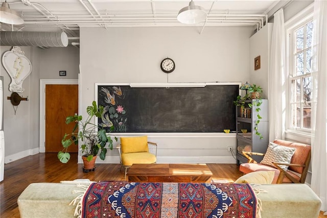 sitting room with baseboards and wood finished floors