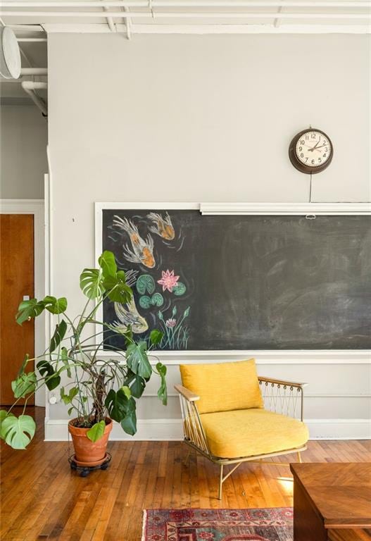 living area featuring hardwood / wood-style floors and baseboards