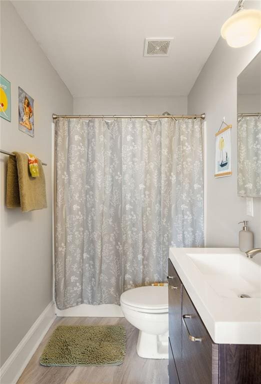 full bathroom with baseboards, visible vents, toilet, wood finished floors, and vanity