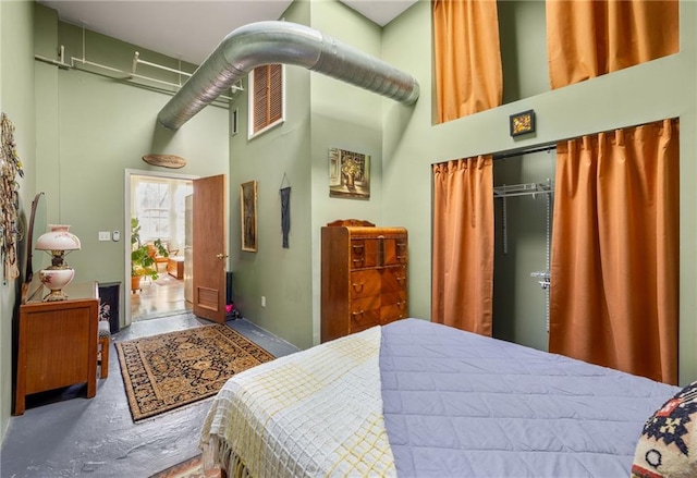 bedroom with a closet and a towering ceiling