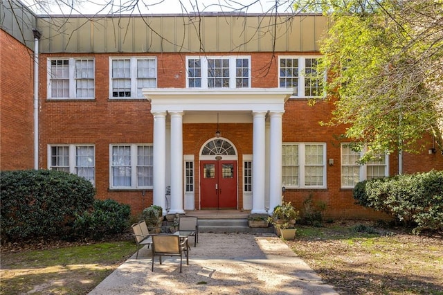 view of front facade with covered porch and brick siding