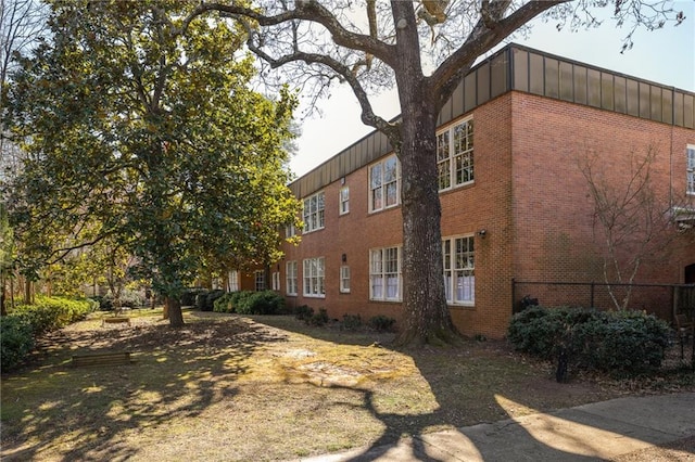 view of side of home featuring brick siding and board and batten siding