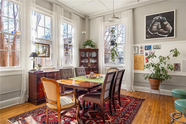 dining space with baseboards and hardwood / wood-style flooring