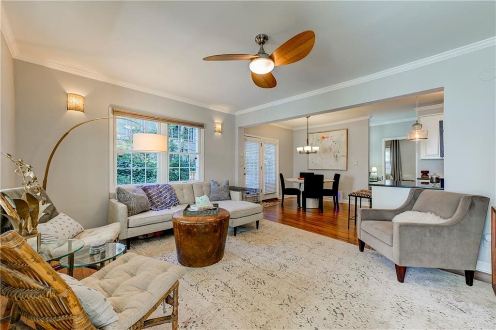 living room featuring hardwood / wood-style floors, ceiling fan, and crown molding