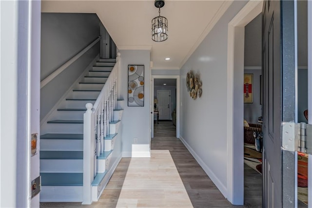 foyer featuring ornamental molding, a chandelier, and light wood-type flooring