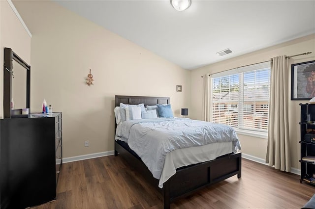 bedroom featuring lofted ceiling, dark wood-style floors, and baseboards
