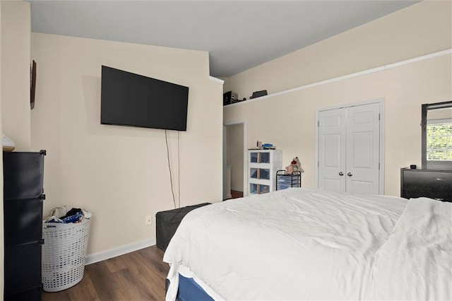 bedroom featuring freestanding refrigerator, wood finished floors, and baseboards