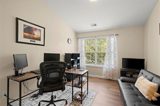 home office featuring wood finished floors, vaulted ceiling, and baseboards