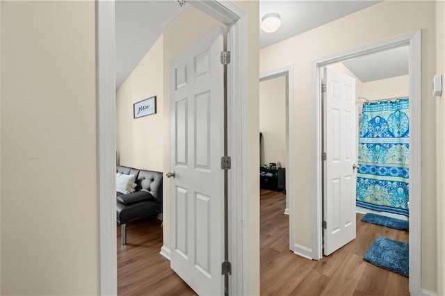 hallway with wood finished floors and baseboards