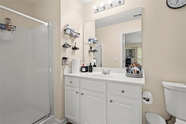 full bath with a stall shower, toilet, and vanity