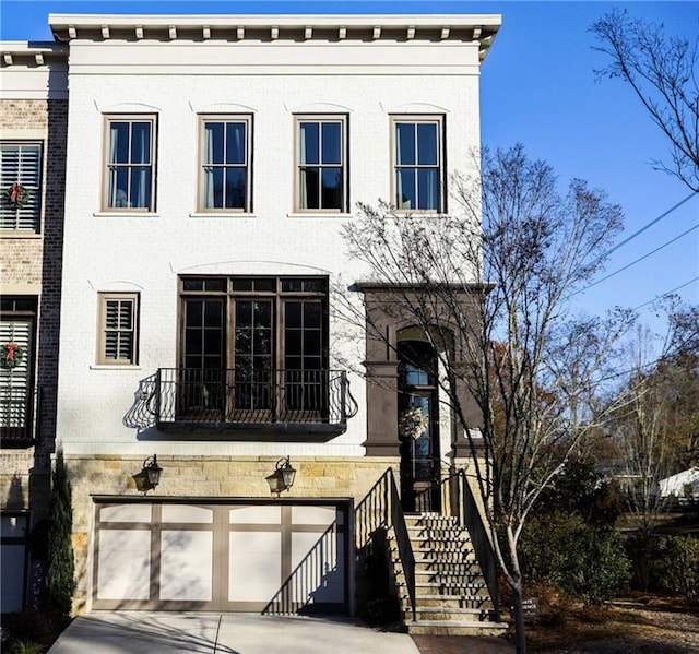 view of front of property featuring a garage and a balcony