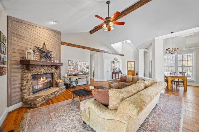 living room with beamed ceiling, a stone fireplace, high vaulted ceiling, and light hardwood / wood-style floors