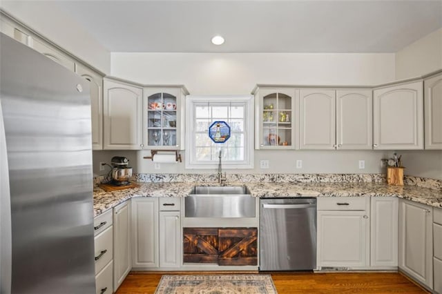 kitchen featuring light stone counters, sink, white cabinetry, and appliances with stainless steel finishes