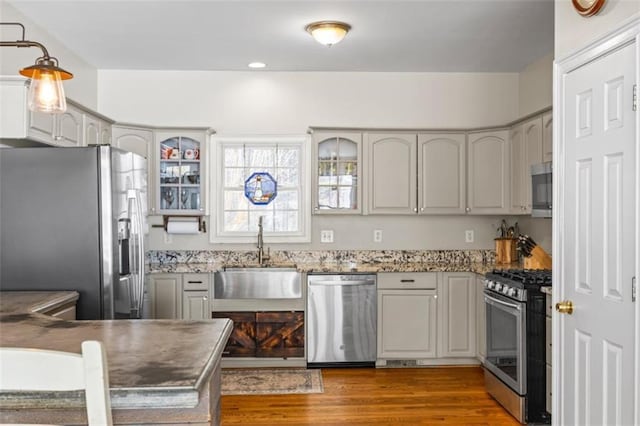 kitchen with sink, hanging light fixtures, dark hardwood / wood-style floors, gray cabinets, and stainless steel appliances