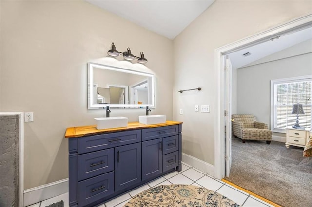 bathroom with vanity, vaulted ceiling, and tile patterned floors