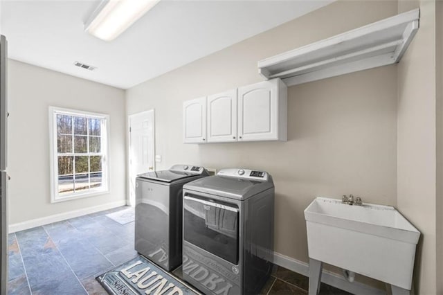 laundry area featuring cabinets, sink, and washer and dryer