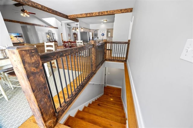 staircase with vaulted ceiling with beams and hardwood / wood-style flooring