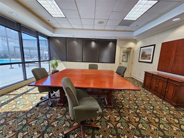 carpeted office with a paneled ceiling and a tray ceiling