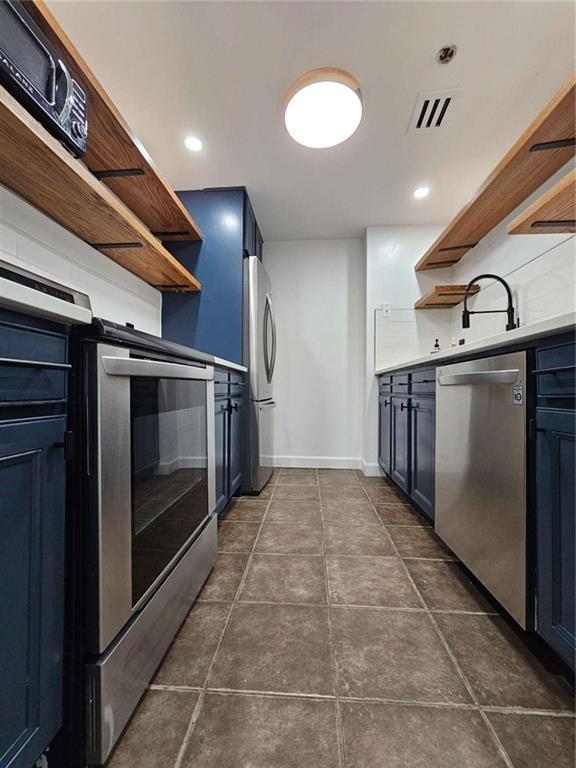 kitchen with appliances with stainless steel finishes, blue cabinets, and sink