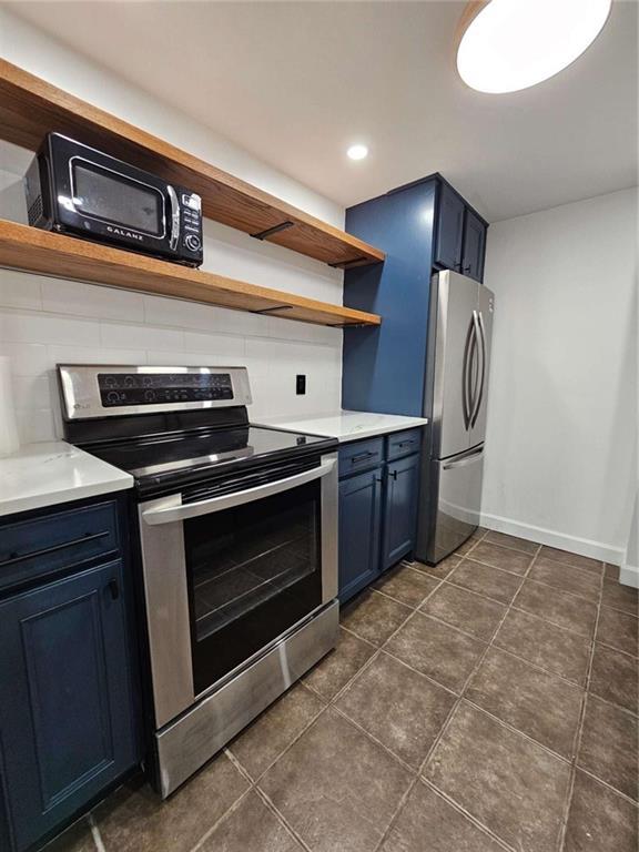 kitchen featuring stainless steel appliances, tasteful backsplash, and blue cabinets