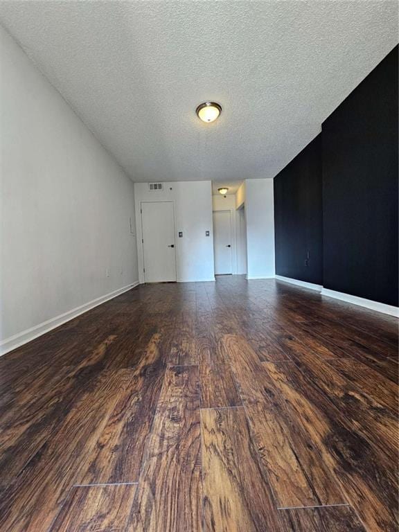 empty room featuring hardwood / wood-style flooring and a textured ceiling