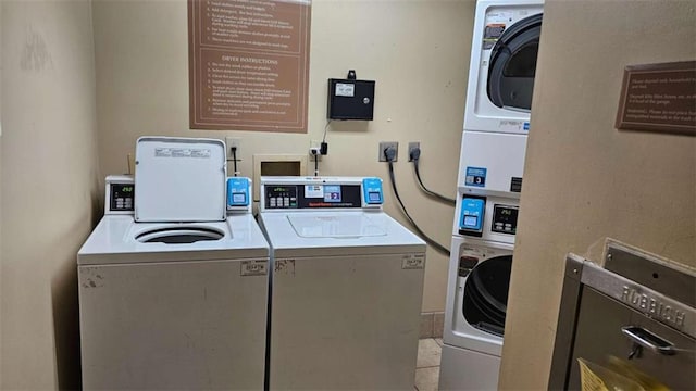 laundry area featuring stacked washer and dryer, washing machine and dryer, and light tile patterned flooring