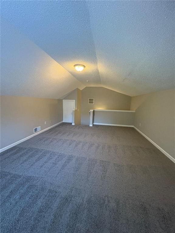 12 Barrington Ct, Sharpsburg, GA 30277 - bonus room featuring a textured ceiling, lofted ceiling, and dark colored carpet