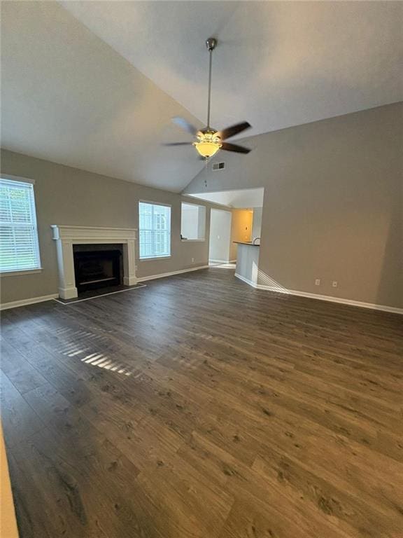 12 Barrington Ct, Sharpsburg, GA 30277 - unfurnished living room with dark wood-style flooring, ceiling fan, a fireplace with raised hearth, and vaulted ceiling