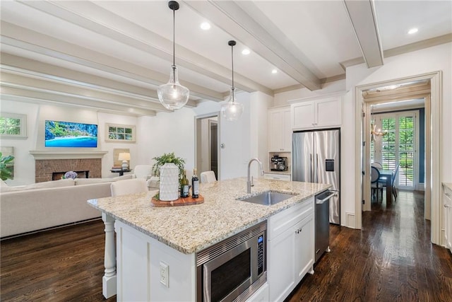 175 Centennial Trce, Roswell, GA 30076 - kitchen featuring appliances with stainless steel finishes, dark wood-style floors, beam ceiling, an island with sink, and light stone counters