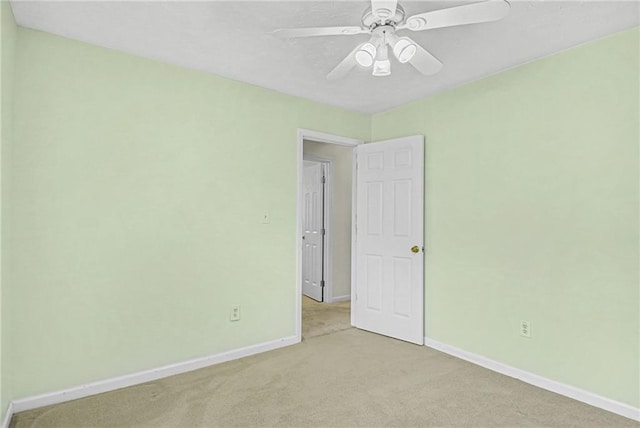 spare room with a ceiling fan, carpet, and baseboards