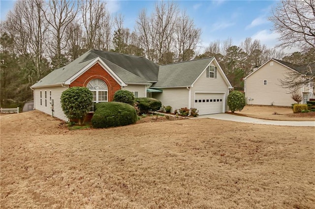 view of front of home featuring a garage, concrete driveway, and brick siding